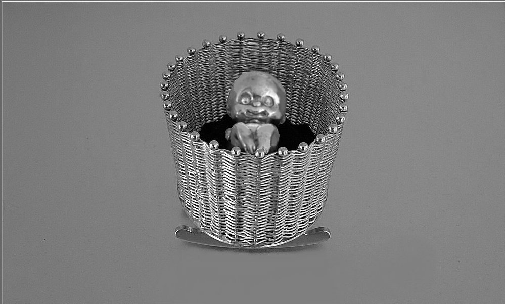 Rockable sterling silver woven crib and newborn baby